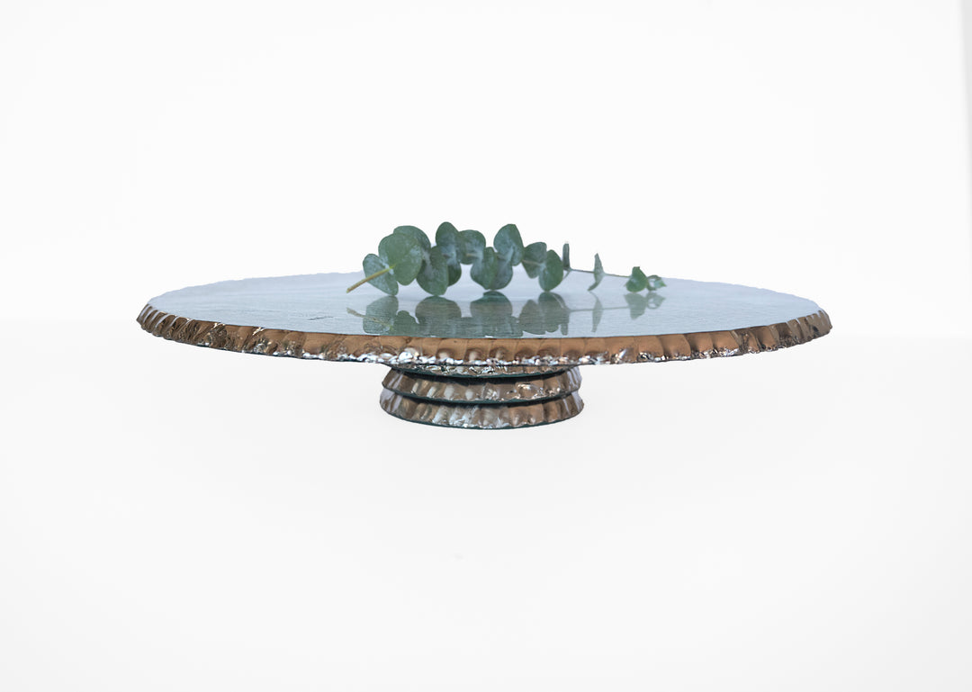 Edgey cake plate with a platinum rim and base with a eucalyptus on top.