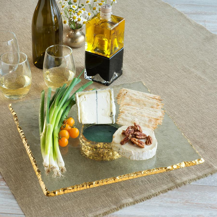 Edgey square 24k gold cake stand with cheese and crackers and veggies on top.