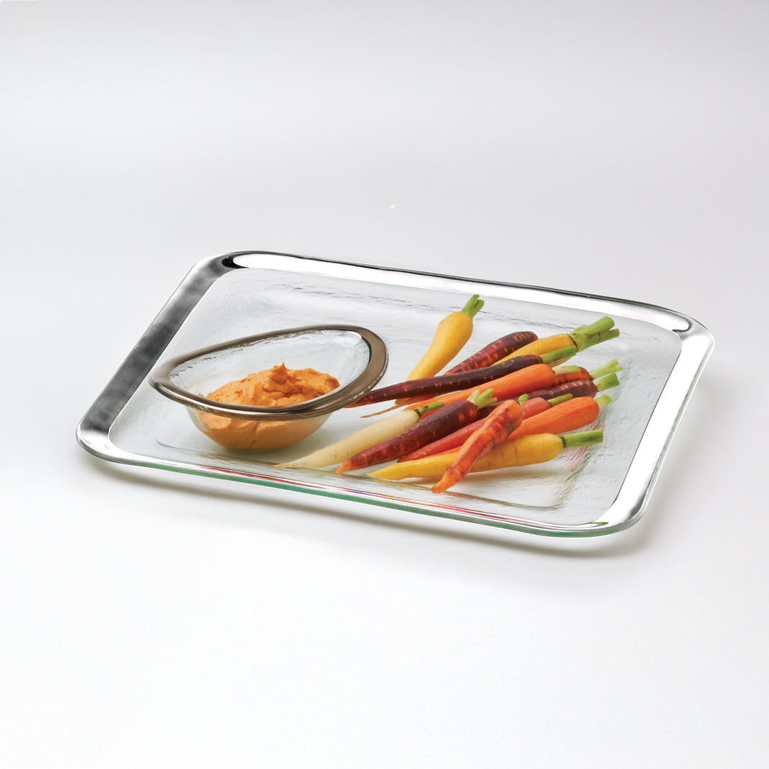 Large buffet server with a platinum band and a small sauce bowl also with a platinum band and carrots.