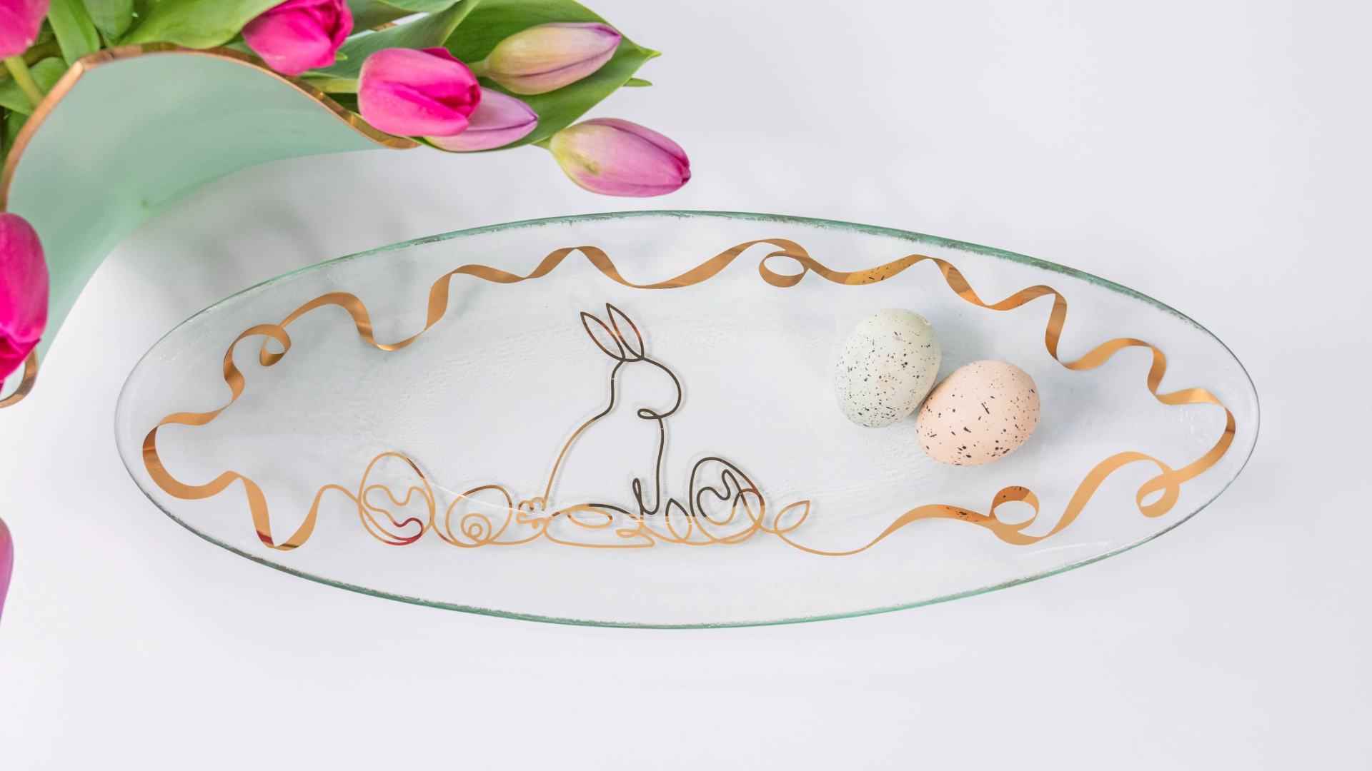 Decorative glass plate with gold rabbit design on a white background