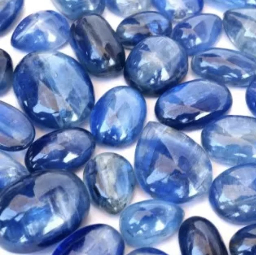 Collection of blue oval-shaped stones, Kyanite, on a white background
