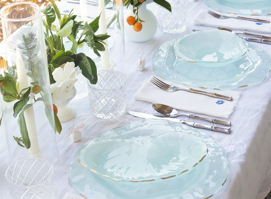 Banner image of summertime table setting with Anneglass Shell dishes silverware, and white tablecloth.